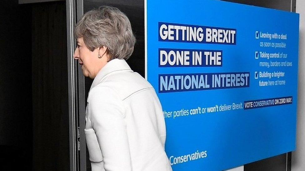 Theresa May by an Conservative European election placard