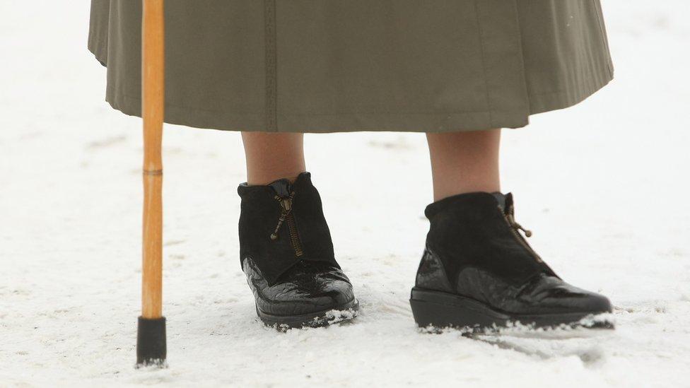 Close-up of elderly woman's shoe in the snow