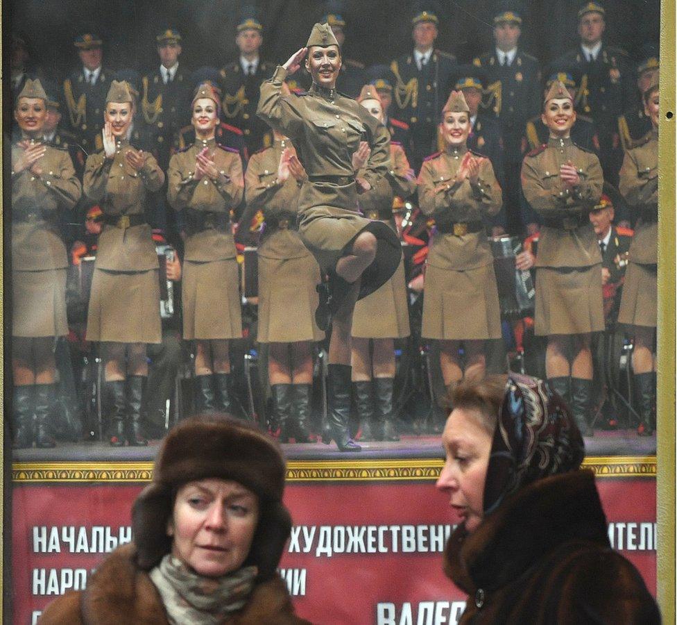 People pay tribute in front of the home stage building of the Alexandrov Ensemble in Moscow, 26 December