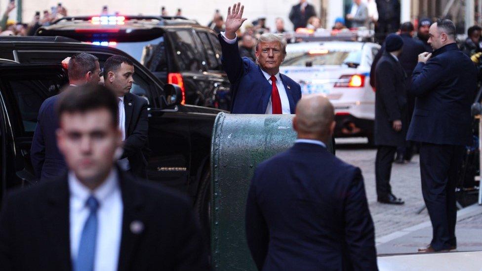 Trump greets media outside court