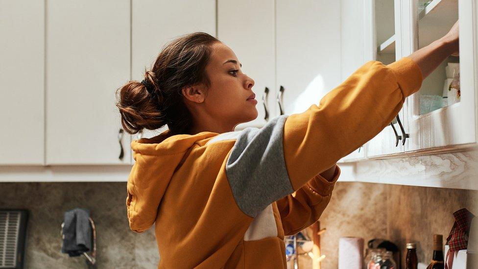 Woman looking in a cupboard