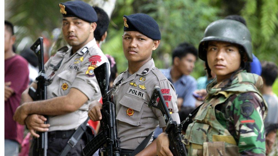 Security forces stand guard at the scene of a burned Church in Aceh Singkil, Indonesia, 14 October 2015