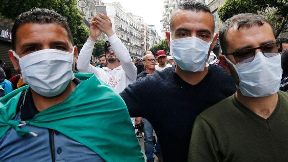 Protesting Algerians wearing mask