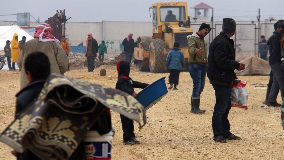 Displaced Syrians fleeing areas in the northern province of Aleppo, gather at the Bab al-Salam camp, outside the town of Azaz (12 February 2016)