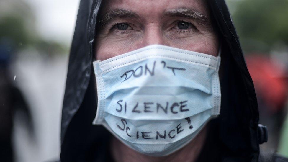 A man with a "Don't Silence Science" mask