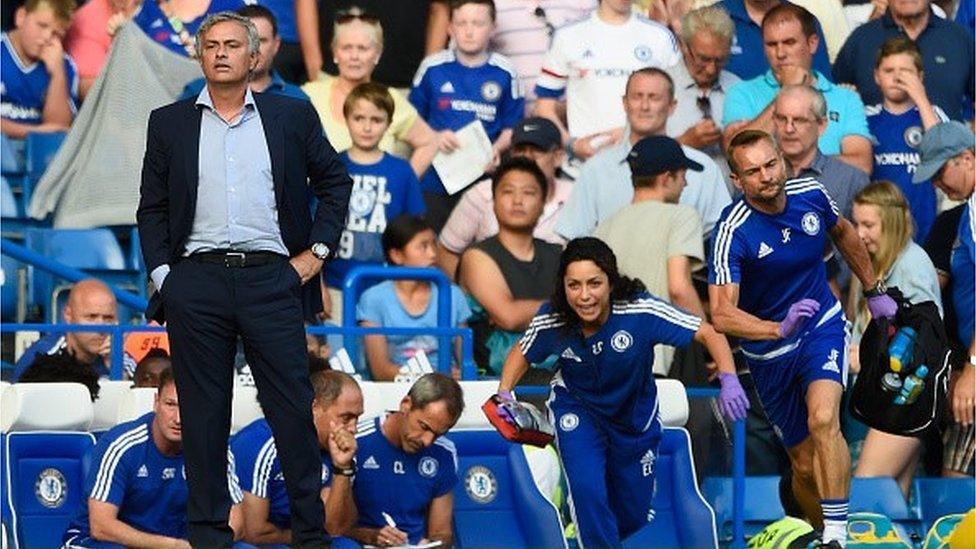 Chelsea manager Jose Mourinho looks on as team doctor Eva Carneiro rushes to treat Eden Hazard during the Barclays Premier League match between Chelsea and Swansea City at Stamford Bridge