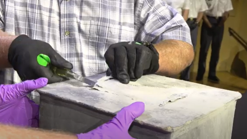 Two West Point employees carefully open the time capsule