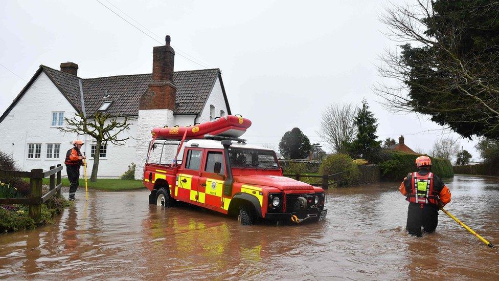 Hereford Fire and Rescue personnel reverse their vehicle as water becomes too deep amid flooding in the village of Hampton Bishop in Herefordshire, western England