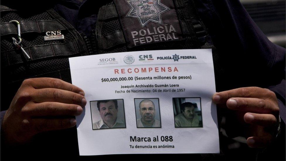 A Federal Police shows a reward notice for information leading to the capture of drug lord Joaquin "El Chapo" Guzman, in Almoloya, west of Mexico City, on 16 July 2015.