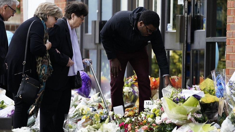 Julia Amess (left) the widow of Conservative MP Sir David Amess, stands with friends and family members to view flowers and tributes left for her late husband at Belfairs Methodist Church in Eastwood Road North, Leigh-on-Sea, Essex, where he died after being stabbed several times during a constituency surgery on Friday.