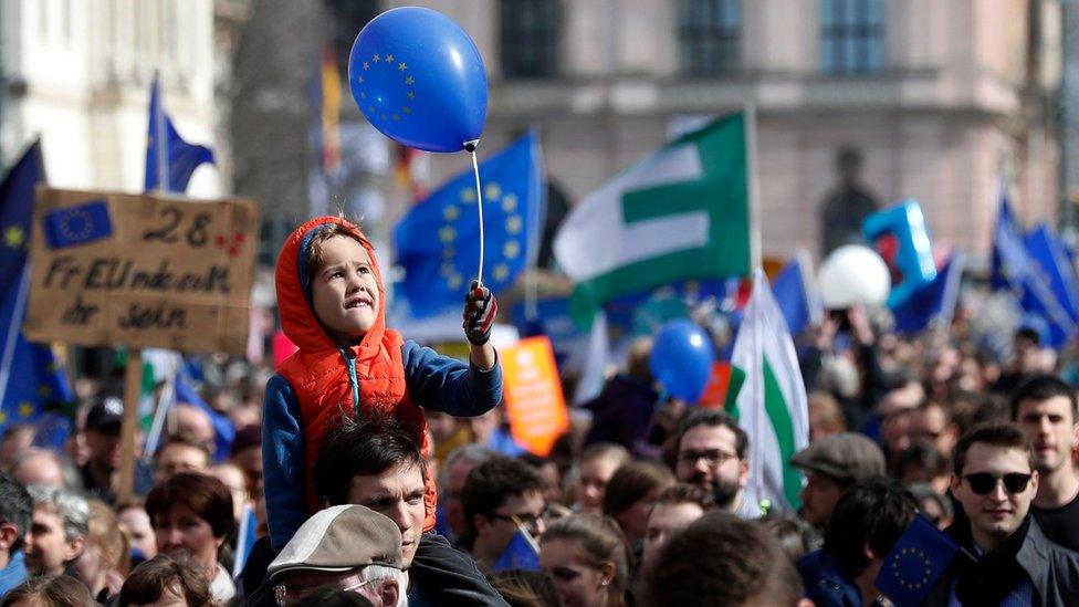 A child holds a balloon with the European logo during the "March for Europe" rally in Berlin, Germany, 25 March 201