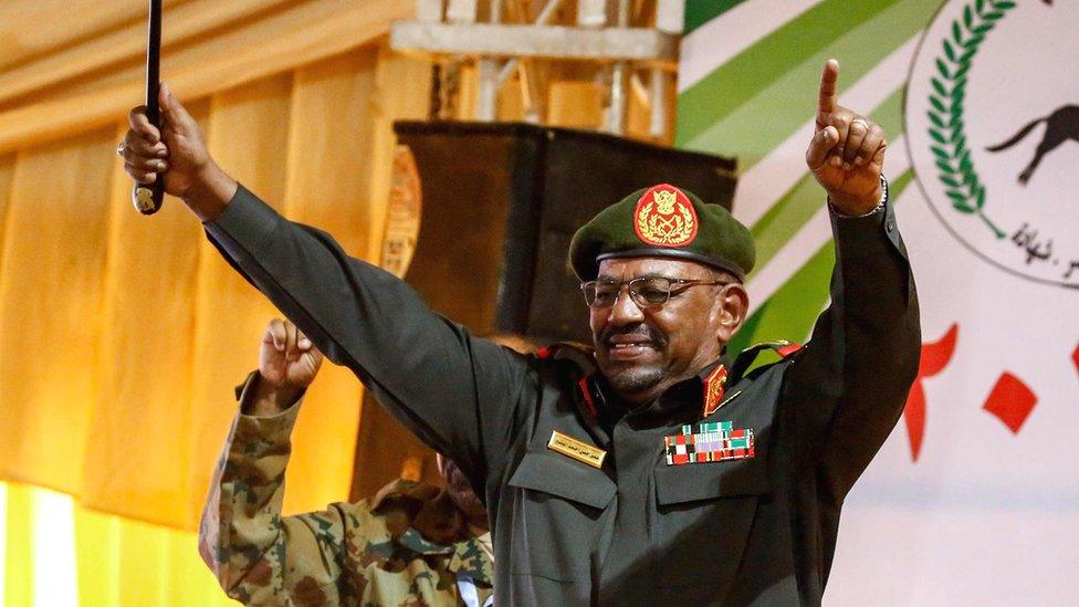 President Omar al-Bashir holds his arms aloft in Sudan while addressing supporters