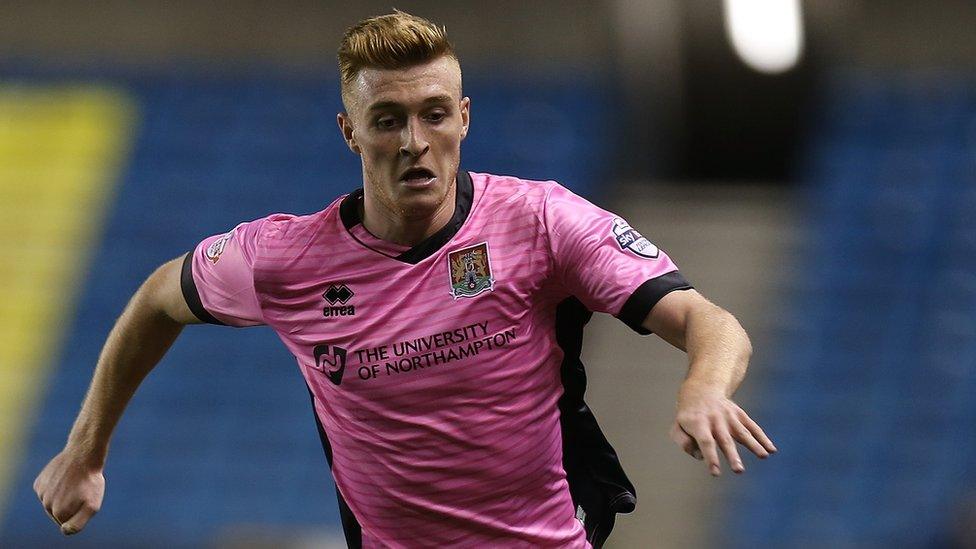 Ryan Watson wearing Northampton Town's pink away shirt