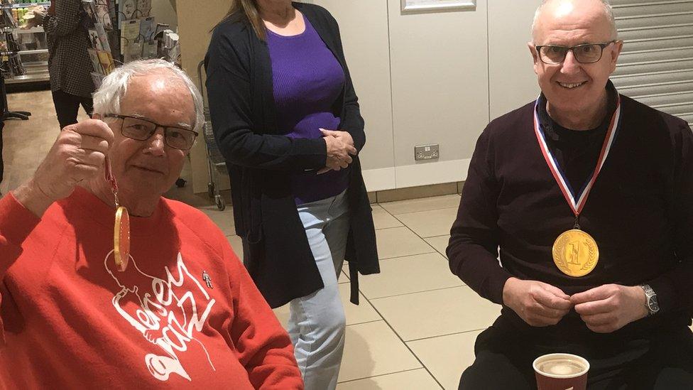 David Wood and Gary Romeril sat at a table holding medals