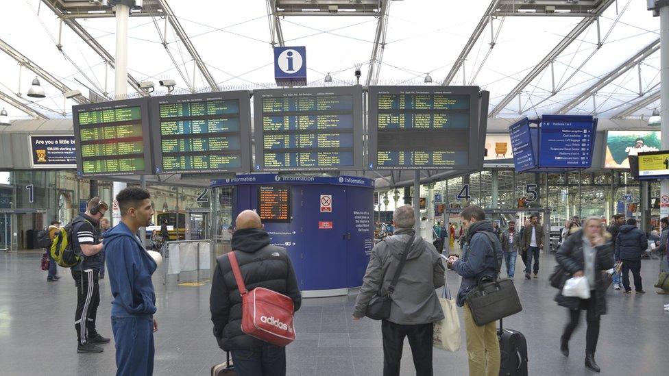 Passengers at departure board Manchester Piccadilly