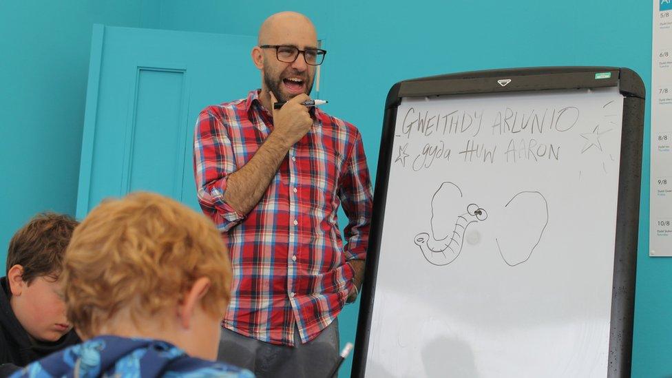 Cartwnydd yn cynnal sesiwn gyda phlant // A cartoonist having fun in a masterclass for children