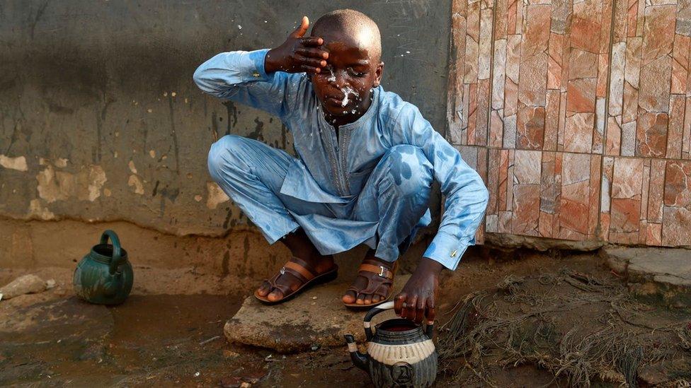 A boy performs the ritual ablutions before praying at a mosque to celebrate Eid al-Fitr at a mosque in Kara Ibafo in Ogun State, on May 24, 2020.