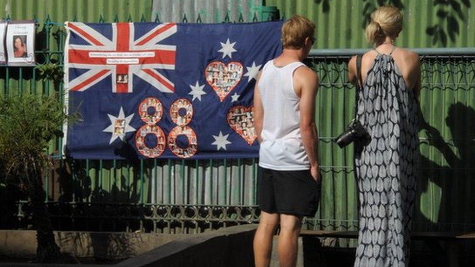 People look at a message on a fence across the street from the Bali bombing memorial on the 11th anniversary of the 2002 terror attack in Kuta, near Denpasar on the Indonesian resort island of Bali.