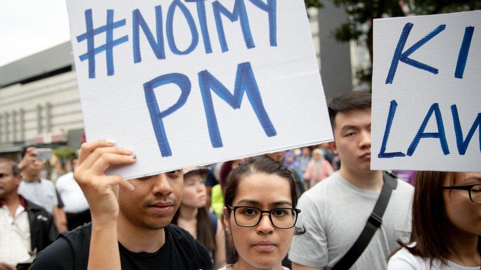 Demonstrators hold placards during a protest