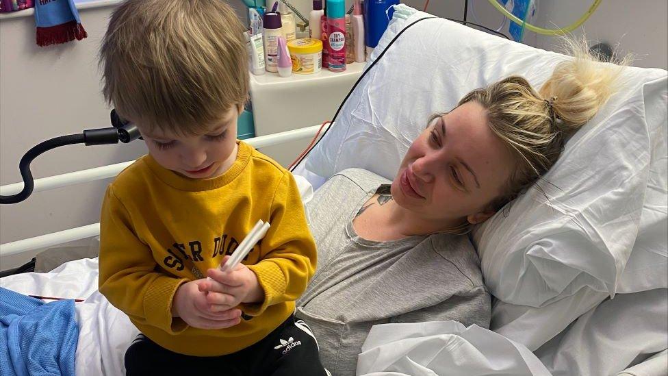 Sadie Kemp in hospital bed with one of her children