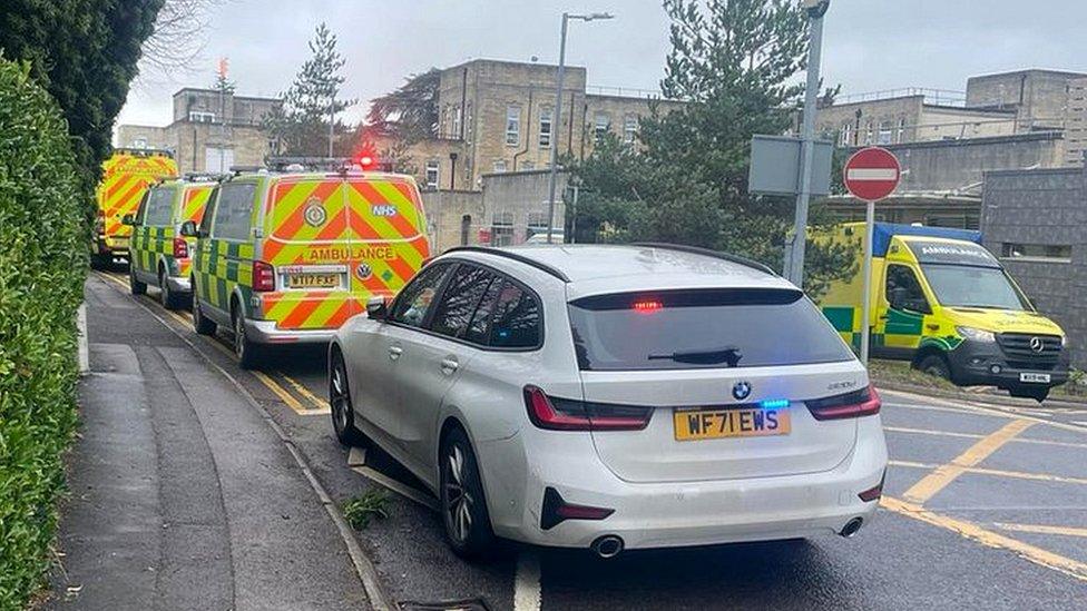 A police car behind ambulances