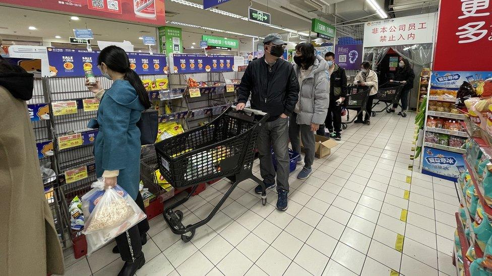 A line of customers waiting to check out at a supermarket in Puxi