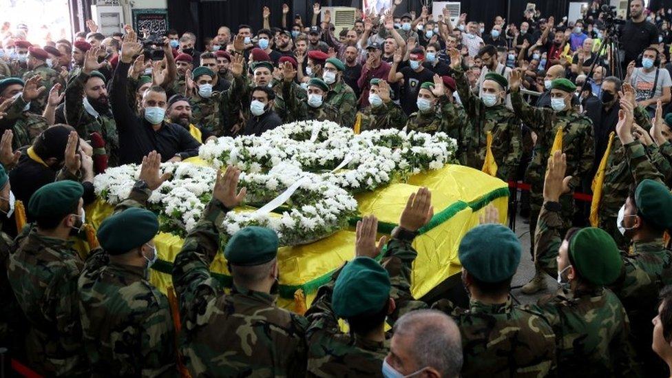 Hezbollah supporters mourn next to the coffins of people killed during violence in Beirut the previous day (15 October 2021)