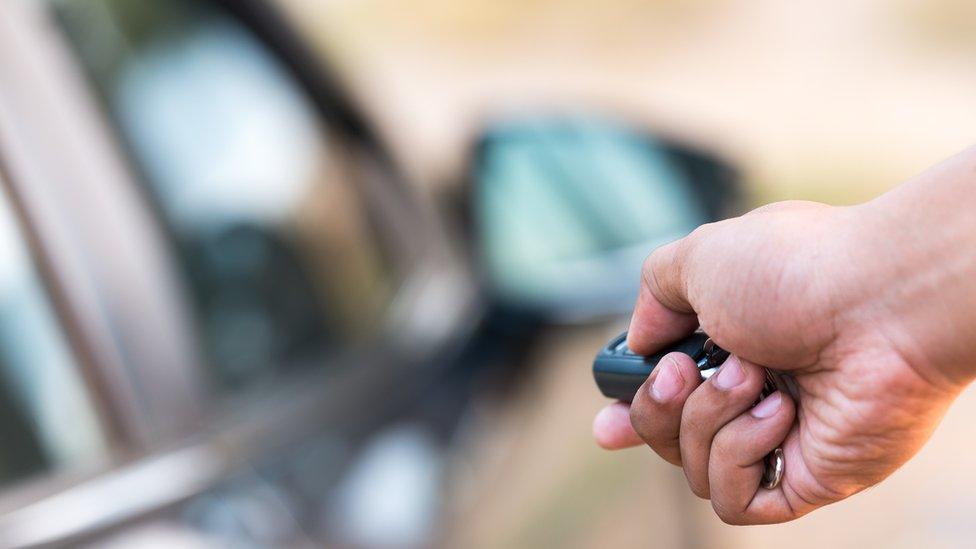 Man opening a car with a key fob fob.