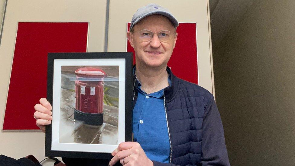 Actor Mark Gatiss holding his artwork