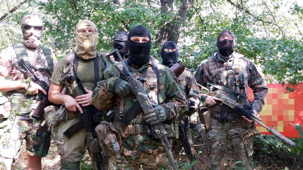 A picture of four men dressed in camouflage and holding guns