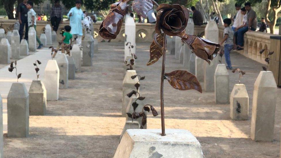 A bronze rose sits on top of the "gravestone"