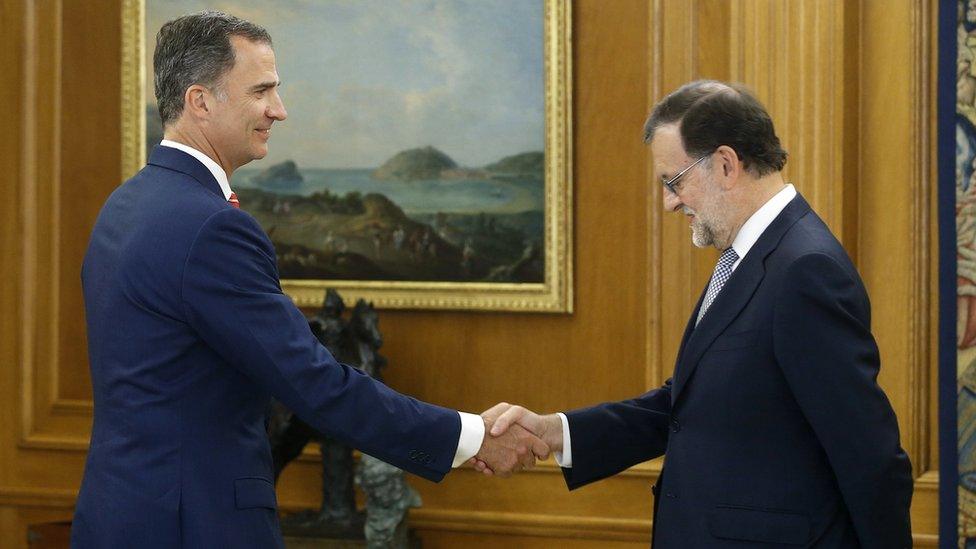 King Felipe VI (L) shakes hands with acting PM Mariano Rajoy (R)