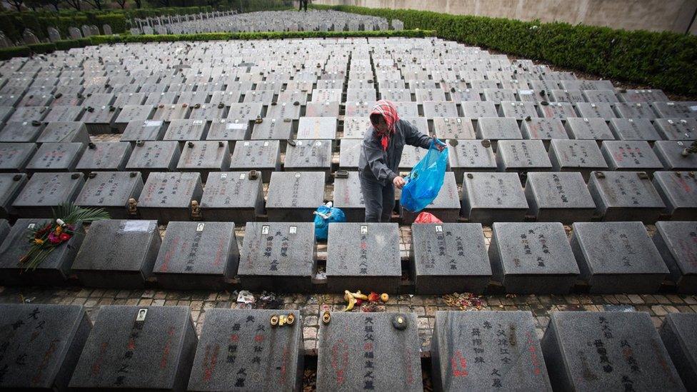 A worker cleans graves during the annual Qingming festival, or Tomb Sweeping Day, at a public cemetery in Shanghai on 6 April 2015.