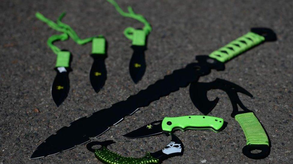 A selection of knives with green handles, some of which have serrated edges