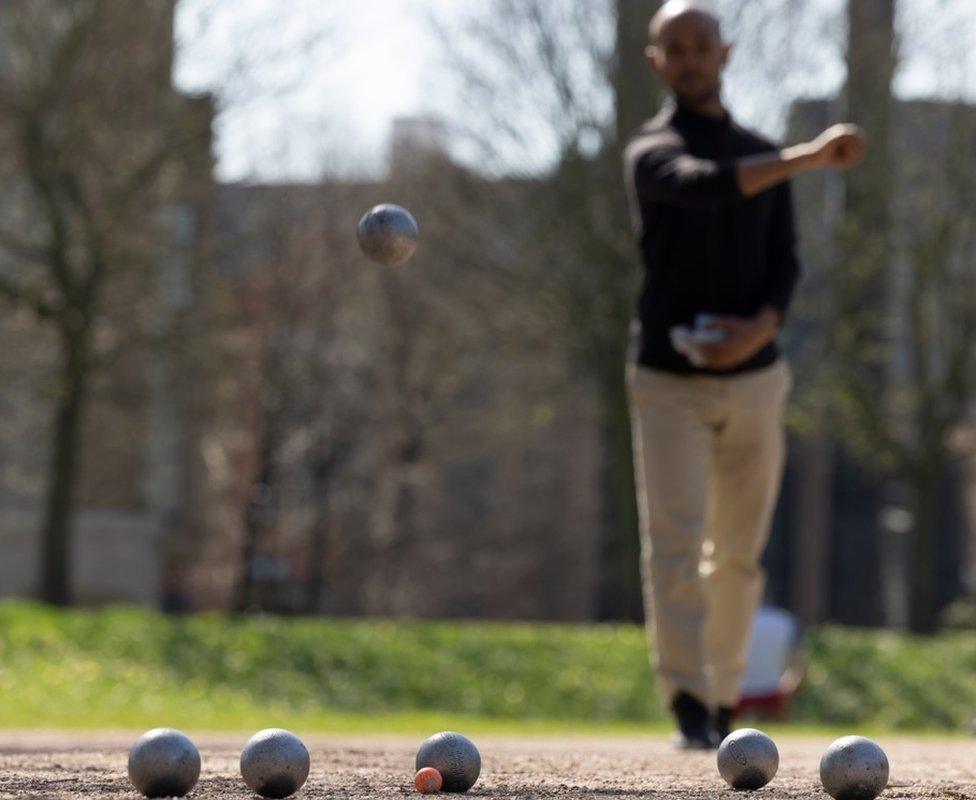 A man playing pétanque