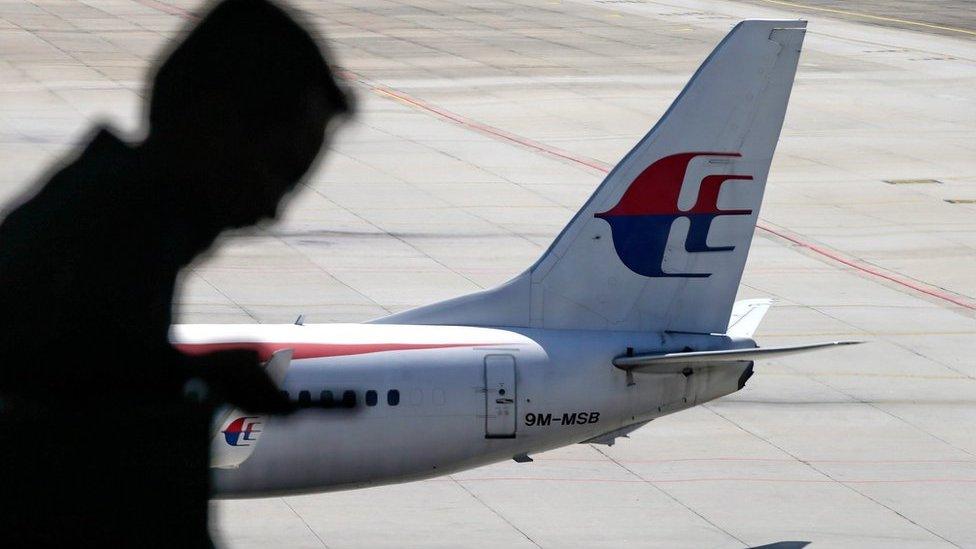 A file picture dated 17 July 2016 shows a passenger walking past a Malaysia Airlines aircraft within a viewing gallery of the Kuala Lumpur International Airport (KLIA) in Sepang, outside Kuala Lumpur, Malaysia.