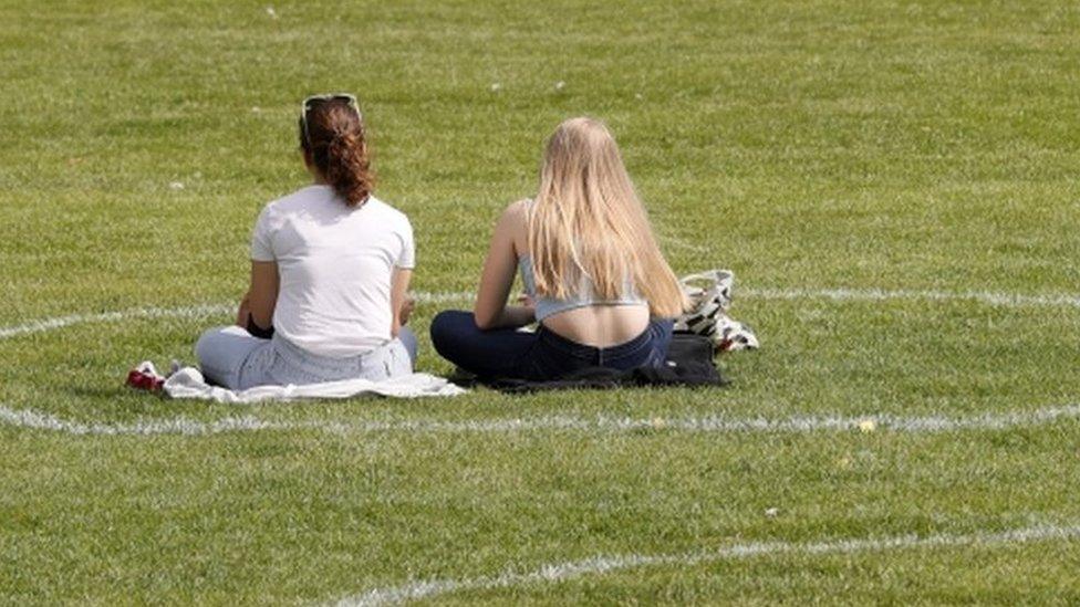 Two Germans sit in a painted circle in a park