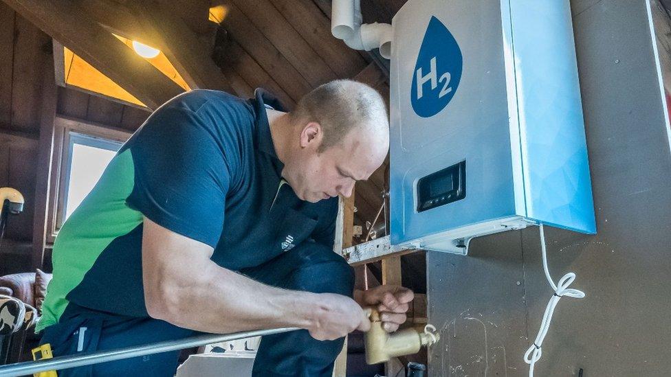 A man fitting a hydrogen boiler