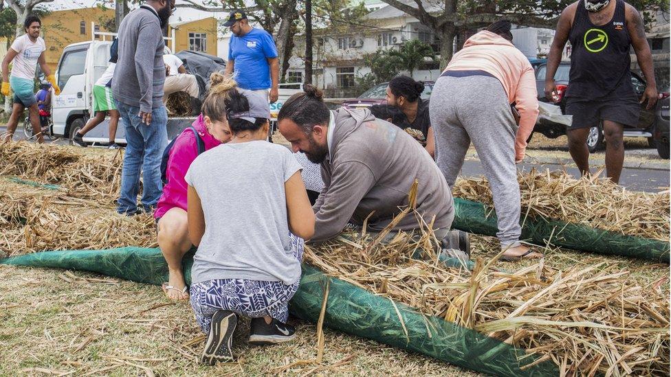 Local volunteers make absorbent barriers of straw stuffed into fabric sacks to contain oil from the MV Wakashio, a Japanese owned Panama-flagged bulk carrier ship which is leaking oil as it recently ran aground off the southeast coast of Mauritius, 07 August 2020