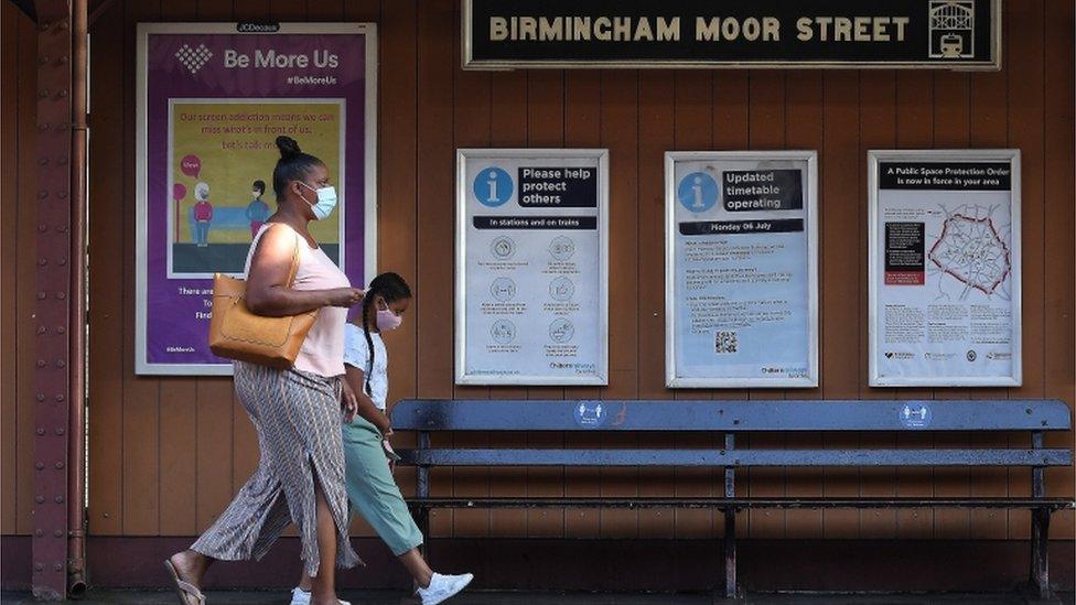 girl with mother walking on train platform