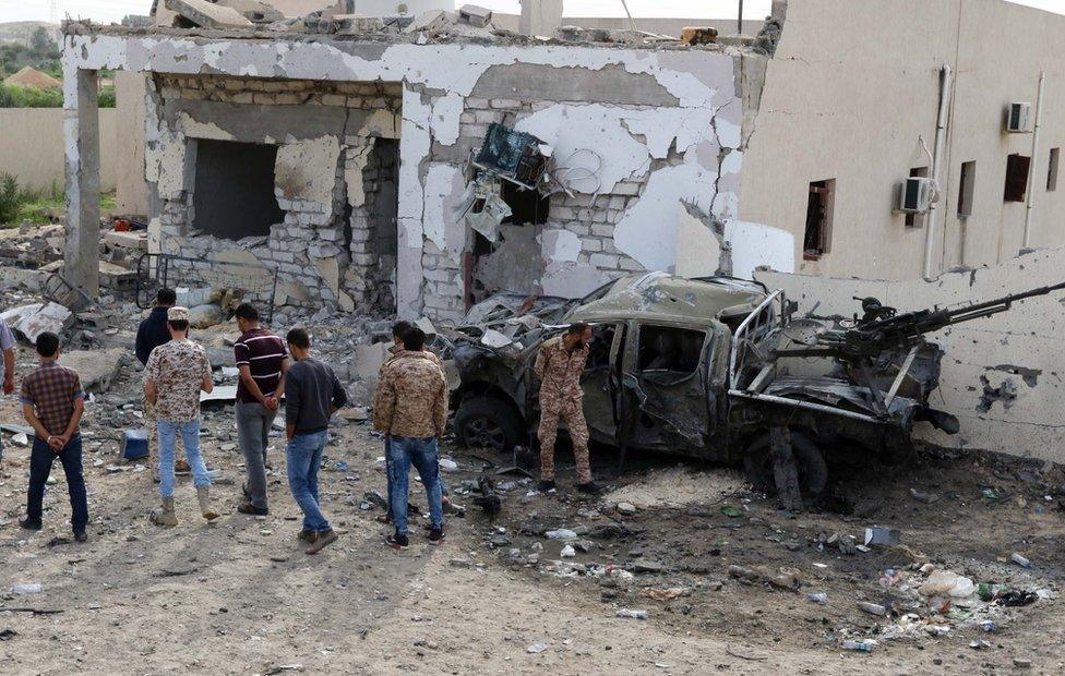 Libyans gather at a checkpoint after it was hit in a bomb attack at Msillata, near Khoms, 120 kilometres from Tripoli in November 2015