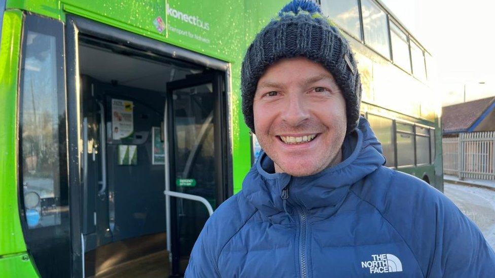 Passenger Gareth Ball stands next to the Park and Ride bus.