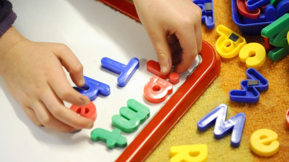 Child using magnetic letters on a board