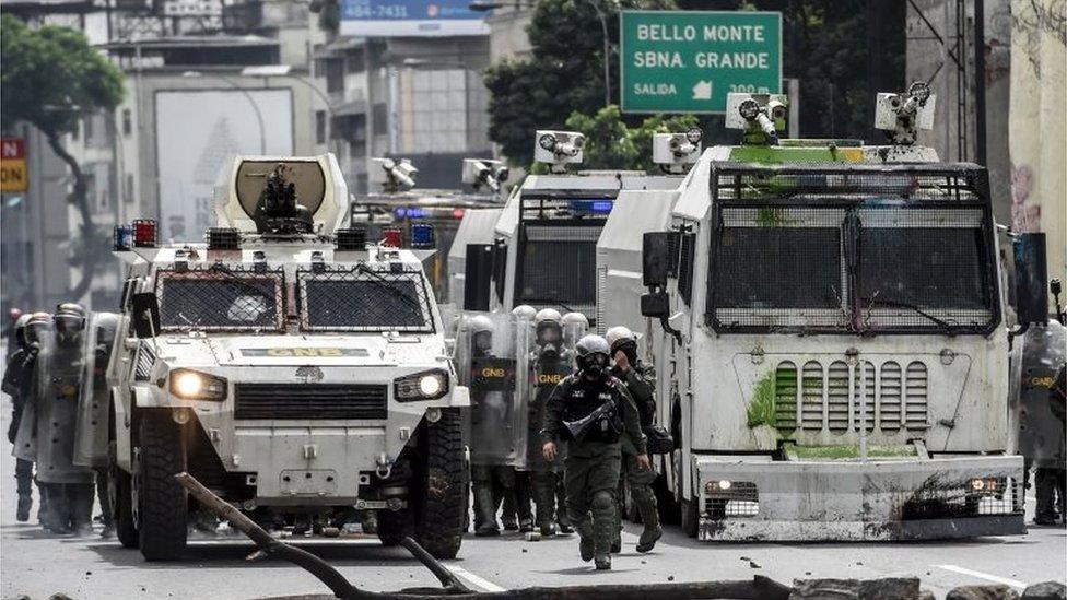 Riot policemen clash with opposition demonstrators during a health care personnel march in Caracas on May 22, 2017.