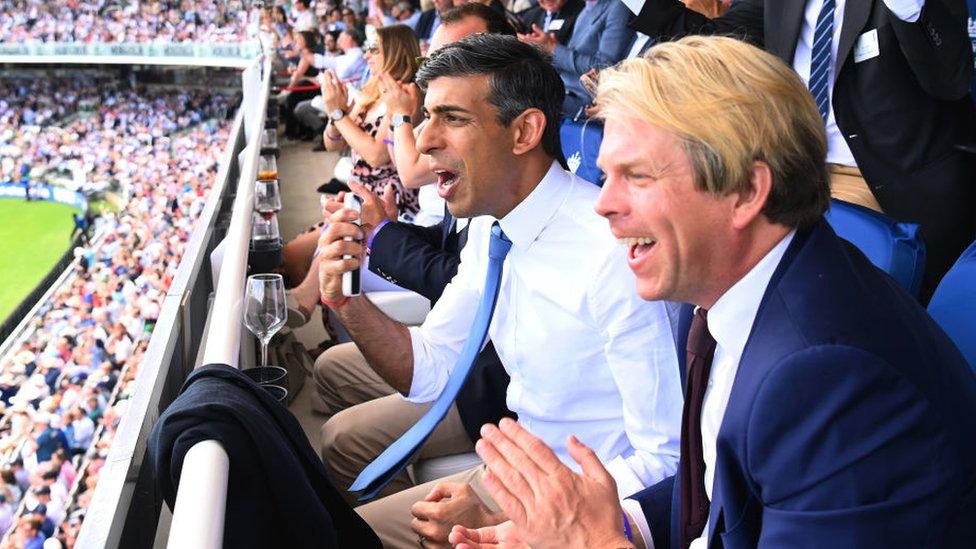 Rishi Sunak watching a cricket match with Charles Banner KC