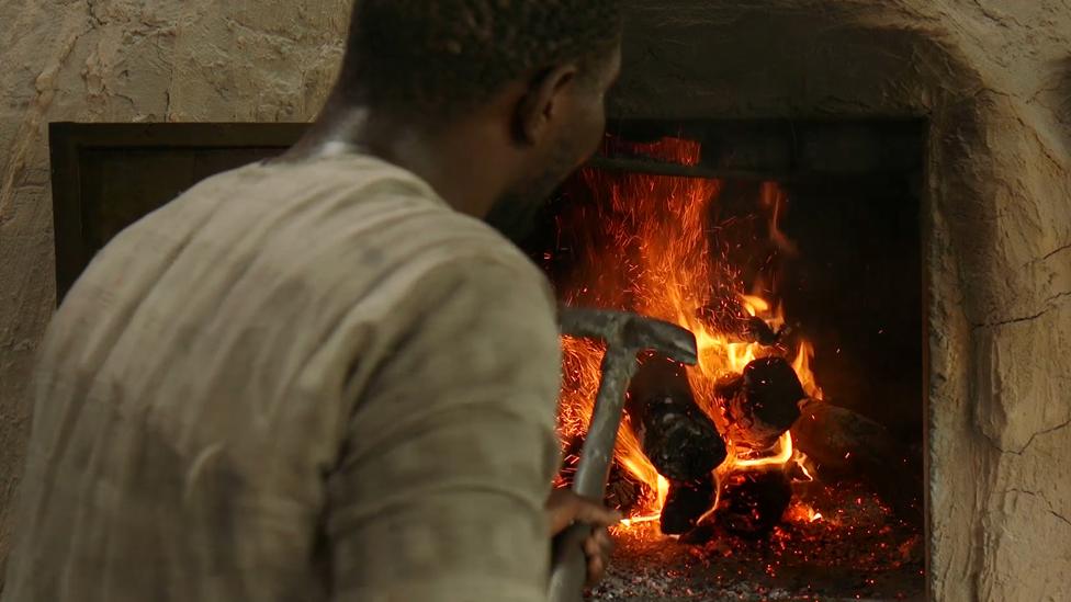 A man tends the bakery fire