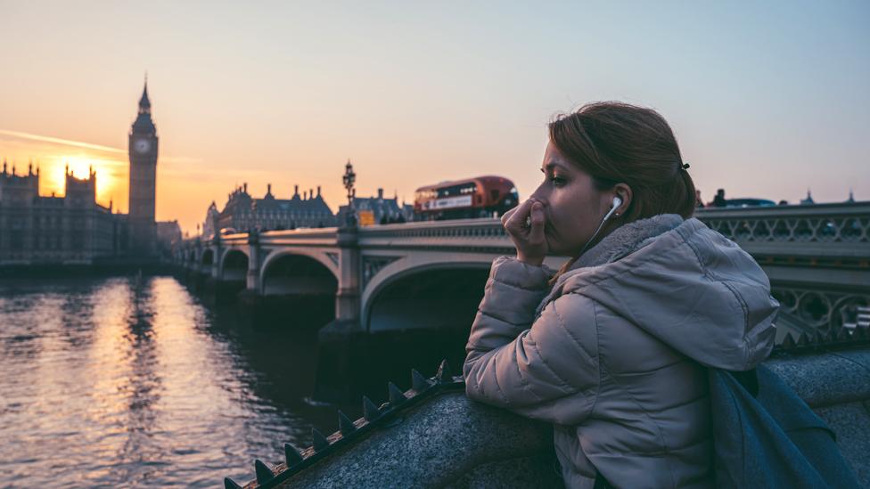 Woman looking across the Thames at Parliament