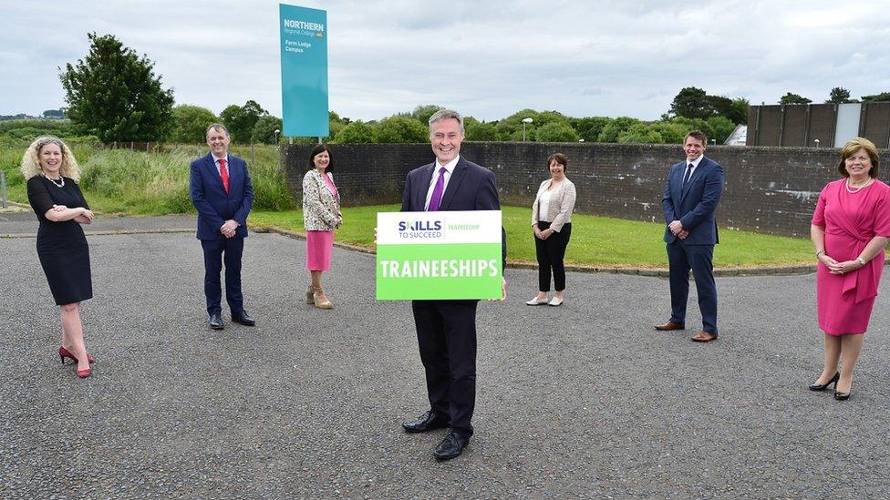 Paul Frew pictured holding a sign saying 'Traineeships' with a number of stakeholders standing behind him