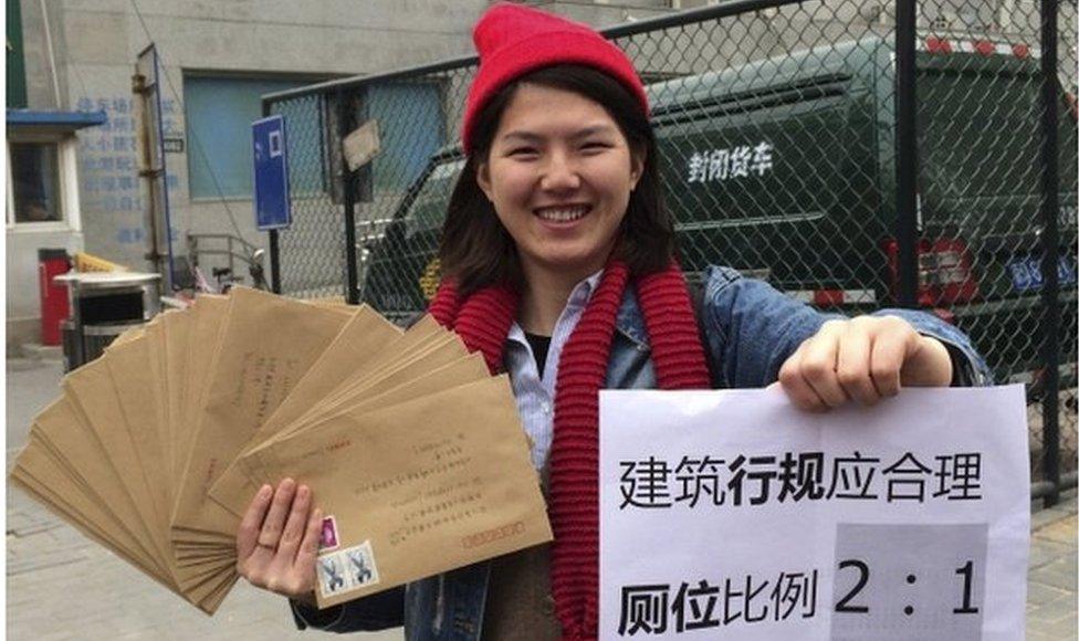 Women activist Li Tingting, 25, poses with letters and a paper which read "Construction regulations should be reasonable, bathroom proportion 2:1 (women/men)" in this undated file handout picture taken in an unknown location in China, provided by a women"s rights group on 8 April 2015