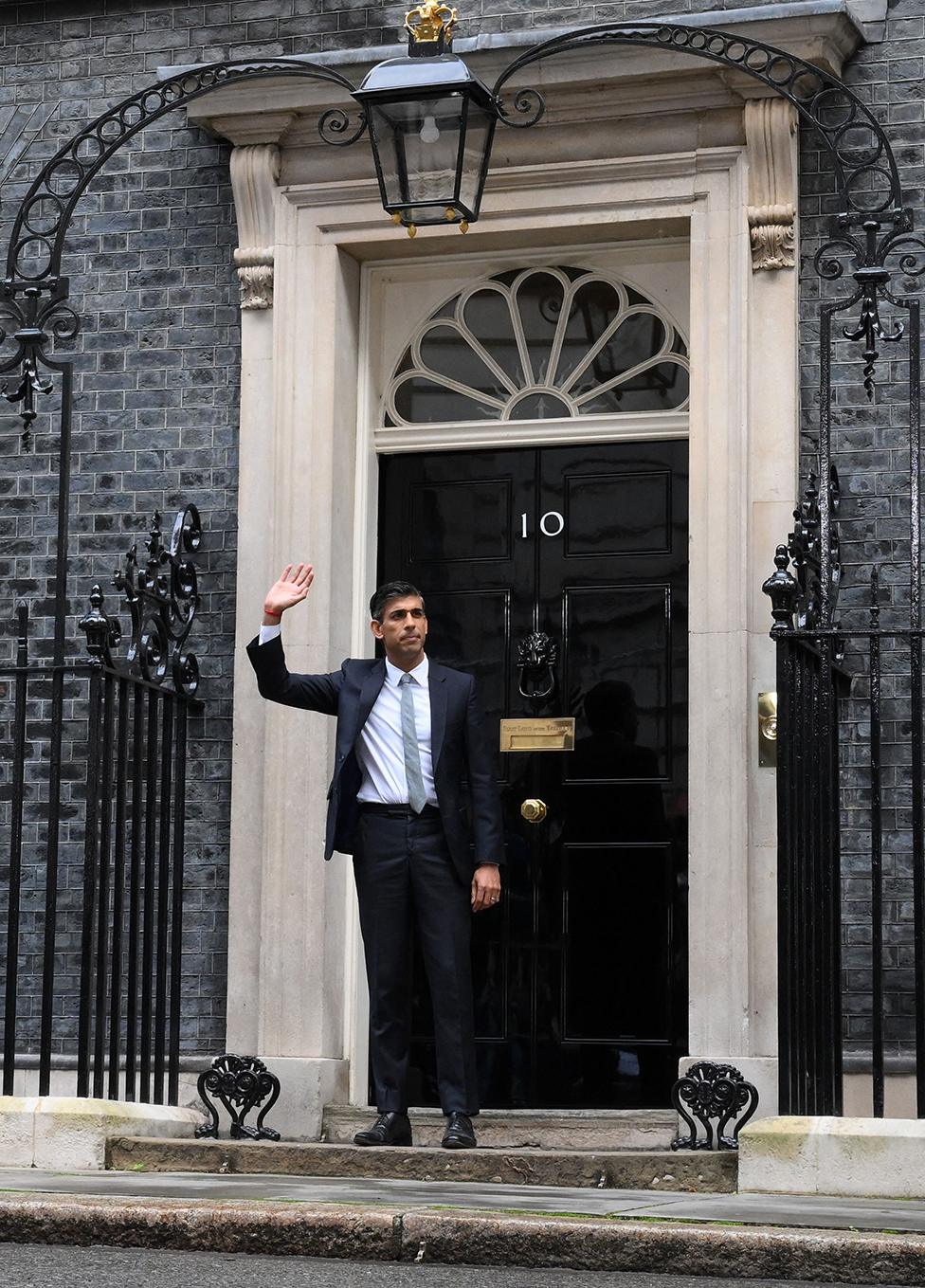 Britain's newly appointed Prime Minister Rishi Sunak waves as he poses outside the door to 10 Downing Street in central London, on 25 October 2022